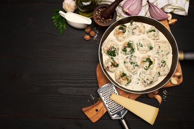 Deliziose polpette con spinaci in salsa cremosa in padella