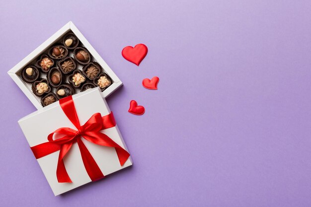 Deliziose praline di cioccolato in scatola rossa per San Valentino Scatola di cioccolatini a forma di cuore vista dall'alto con spazio per la copia