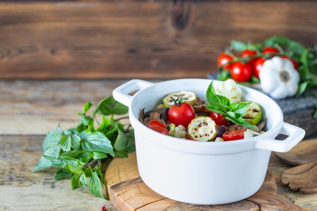 Deliziose verdure grigliate in una casseruola su uno sfondo di legno. concetto di cibo sano. Copia spazio