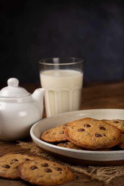 Deliziosi biscotti al cioccolato con bicchiere di latte sul tavolo di legno