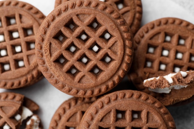 Deliziosi biscotti al cioccolato con crema sul tavolo piatto