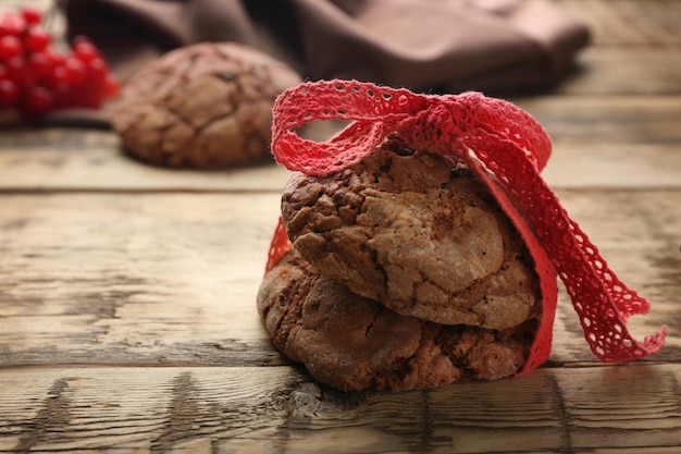 Deliziosi biscotti al cioccolato con nastro su fondo in legno