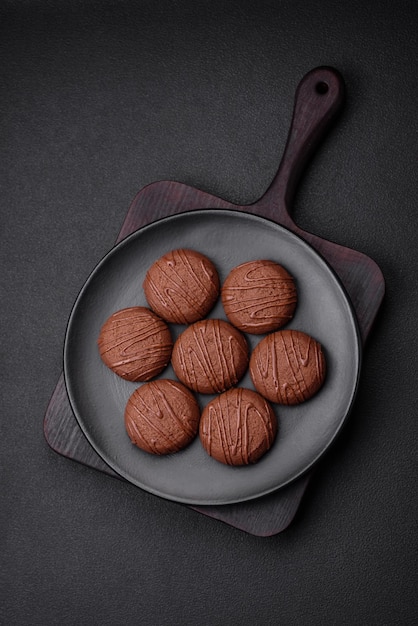 Deliziosi biscotti al cioccolato dolce su un piatto di ceramica nera