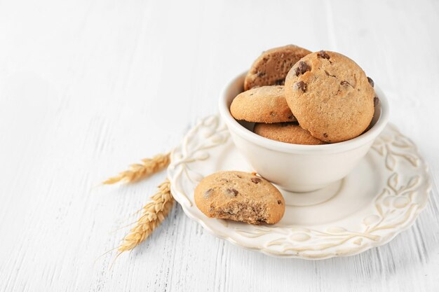 Deliziosi biscotti di farina d'avena con gocce di cioccolato in una ciotola sul tavolo