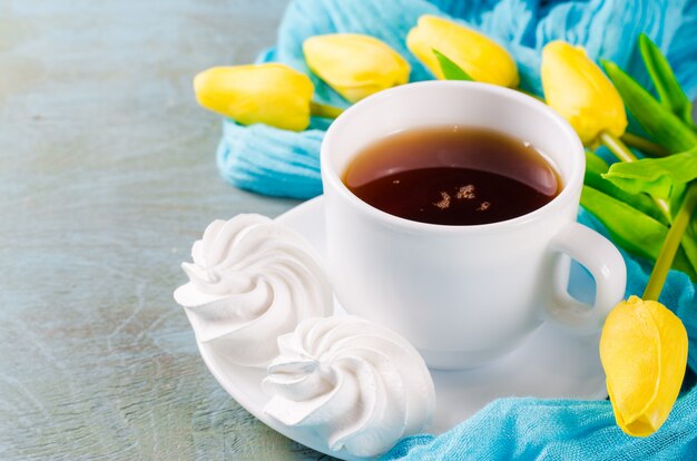 Deliziosi biscotti di meringa e tazza di tè caldo.