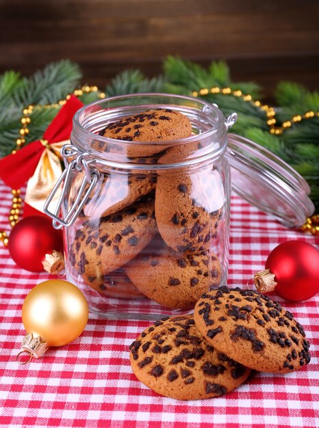 Deliziosi biscotti di Natale in barattolo sul tavolo su fondo di legno