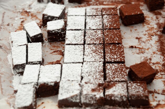 Deliziosi cioccolatini crudi fatti in casa tagliati in forme quadrate cosparsi di zucchero a velo