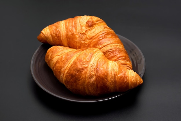 Deliziosi croissant croccanti su uno sfondo nero cucinati in casa