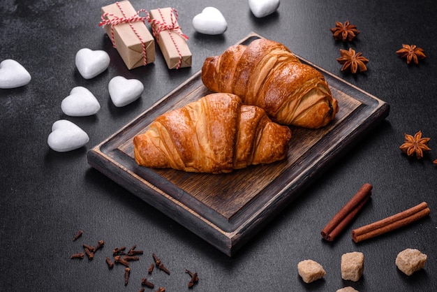 Deliziosi croissant freschi e croccanti su uno sfondo di cemento scuro. Colazione gustosa