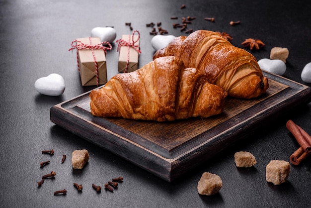 Deliziosi croissant freschi e croccanti su uno sfondo di cemento scuro. Colazione gustosa