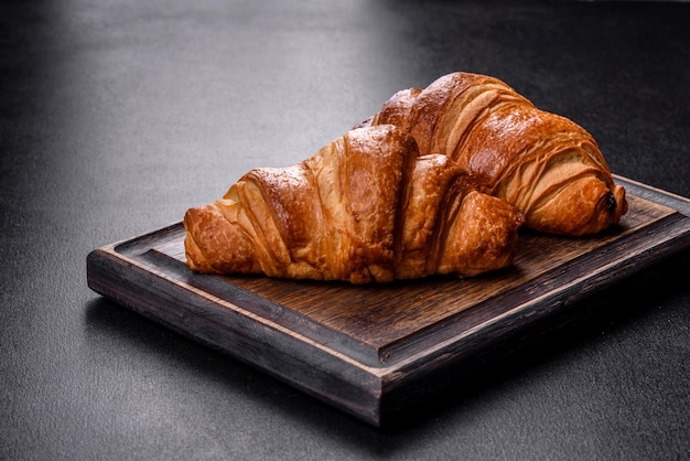 Deliziosi croissant freschi e croccanti su uno sfondo di cemento scuro. Colazione gustosa