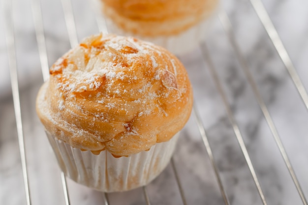 Deliziosi cruffins moderni sono realizzati con croissant a strati a forma di muffin A forma di cupcake. topping alla mandorla.