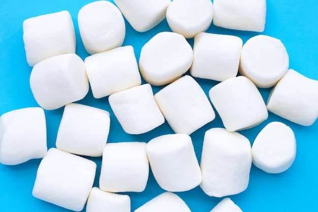 Deliziosi marshmallow bianchi su sfondo blu