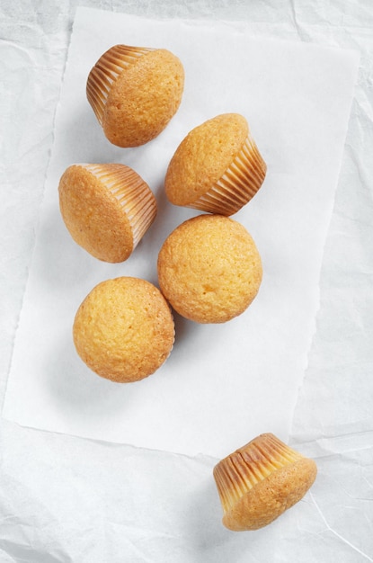 Deliziosi mini muffin su carta bianca stropicciata, vista dall'alto