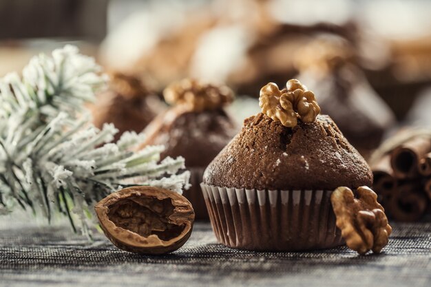 Deliziosi muffin al cioccolato di Natale spolverati con zucchero a velo e noci sulla parte superiore.