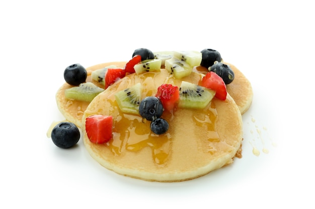 Deliziosi pancake con frutti di bosco e miele isolati su sfondo bianco