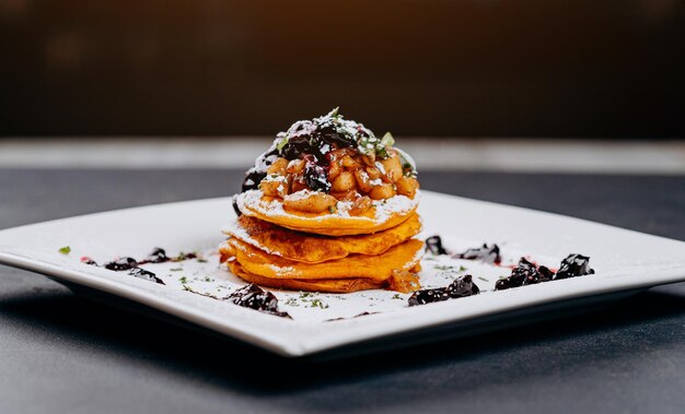 Deliziosi pancakes vengono serviti con marmellata di ribes e mele su un piatto pronto da mangiare