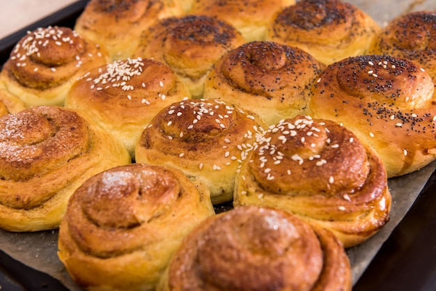 Deliziosi panini al forno con semi di papavero su un vassoio. panetteria fatta in casa