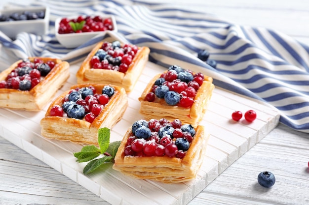 Deliziosi pasticcini sul tagliere di legno bianco