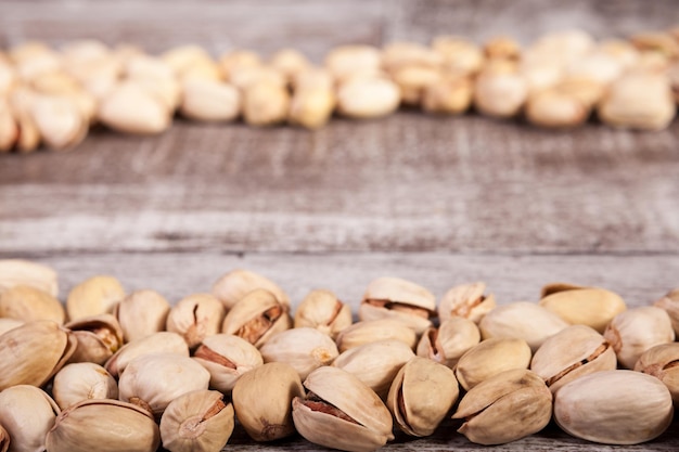 Deliziosi pistacchi su fondo di legno in studio fotografico. Snack sani e deliziosi