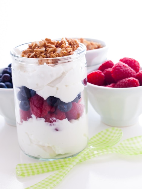 Deliziosi semi di frutta, yogurt greco e muesli su sfondo bianco