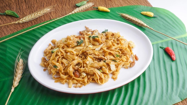 Deliziosi spaghetti di riso fritti o char kway teow o kwetiau con uova e verdure Cibo di strada indonesiano