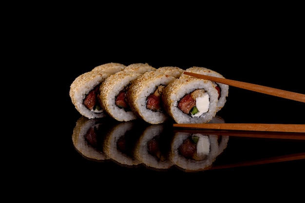 Deliziosi sushi rotoli freschi su uno sfondo scuro