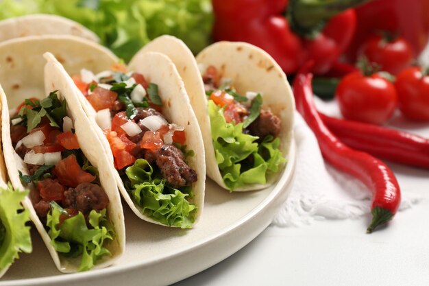 Deliziosi tacos con carne e verdure su un tavolo bianco
