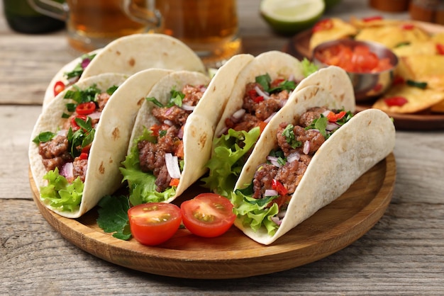 Deliziosi tacos con carne e verdure su un tavolo di legno