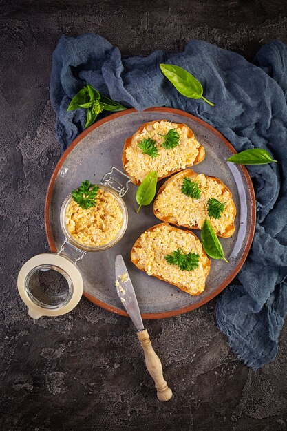 Deliziosi toast con rillettes di pollo fatti in casa. Spuntino a sandwich con patè di pollo su fondo di legno. Vista dall'alto