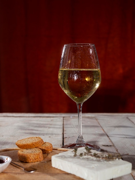 Delizioso antipasto con tagliere di formaggi e un bicchiere di vino bianco