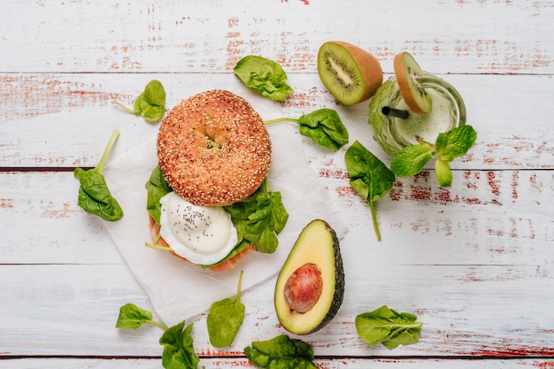 Delizioso bagel con pane al sesamo e chia, al suo interno contiene salmone, uovo fritto e basilico.