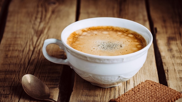 Delizioso cappuccino caldo sulla tavola di legno