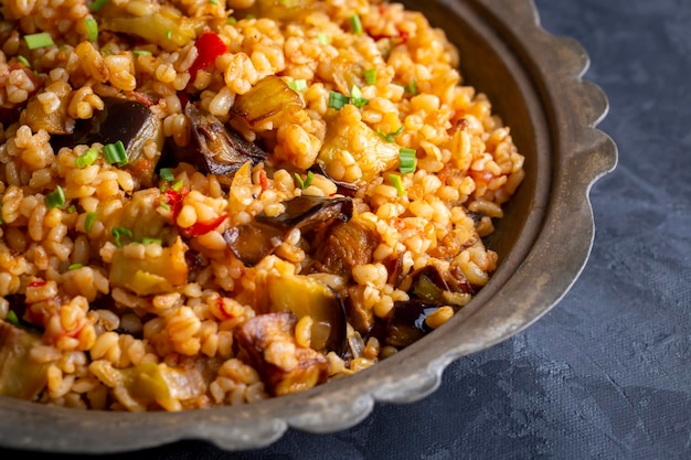 Delizioso cibo turco tradizionale; Bulgur pilaf con melanzane e verdure. (nome turco; Patlicanli bulgur pilavi)