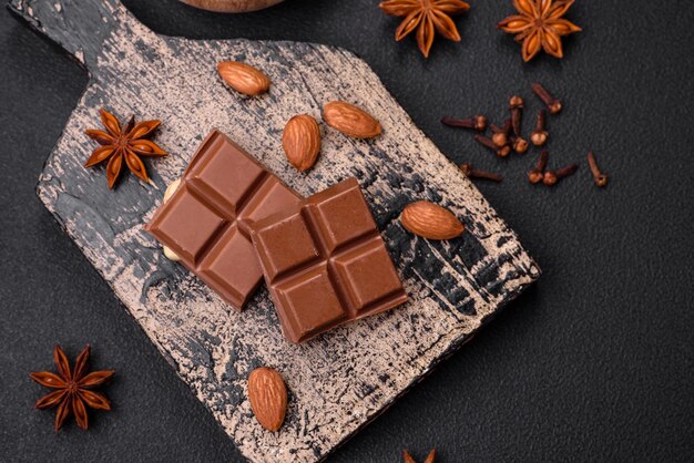 Delizioso cioccolato al latte dolce rotto in cubetti su un tagliere di legno