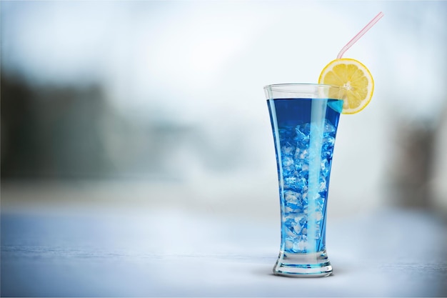 Delizioso cocktail blu con ghiaccio sullo sfondo