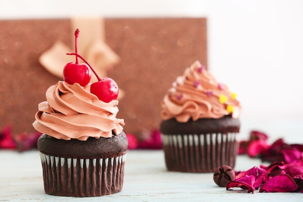 Delizioso cupcake al cioccolato con ciliegie sul tavolo