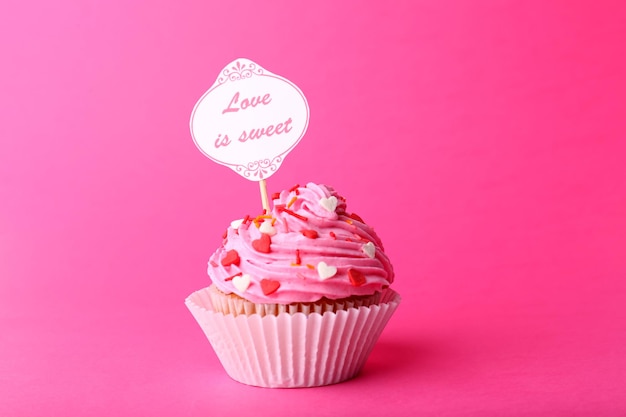 Delizioso cupcake con scritta su sfondo rosa