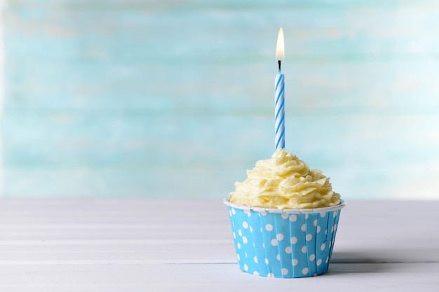 Delizioso cupcake di compleanno sul tavolo su sfondo azzurro