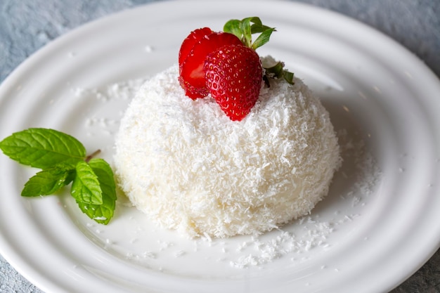 Delizioso dessert al latte; dessert in tazza con cocco e fragola (nome turco; fincan tatlisi