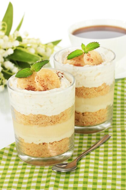 Delizioso dessert con banana e caramello sul tavolo su sfondo bianco