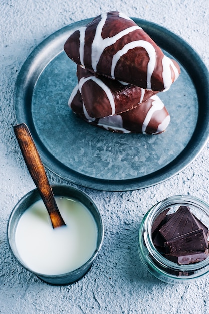 Delizioso dessert fatto in casa di cioccolato bianco e nero riempito con crema. Dessert a forma di triangolo sulla tavola di legno