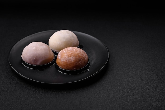 Delizioso dessert mochi dolce con condimenti su uno sfondo di cemento scuro