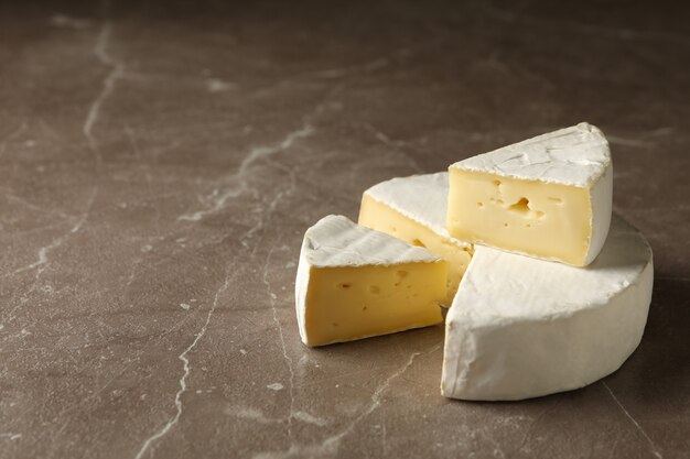 Delizioso formaggio camembert su sfondo grigio, spazio per il testo