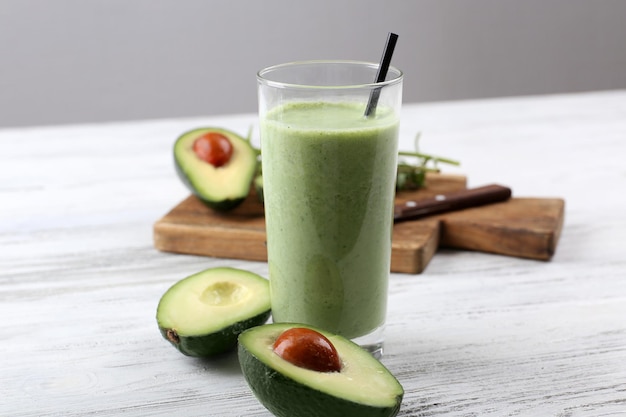 Delizioso frullato di avocado fresco su fondo di legno bianco