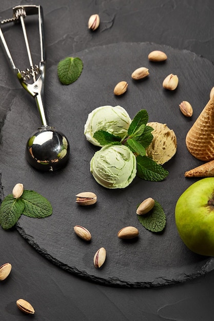 Delizioso gelato al pistacchio e cioccolato decorato con menta fresca e servito su una pietra di ardesia ov