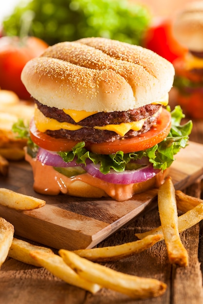 Delizioso hamburger con patate su un tavolo di legno