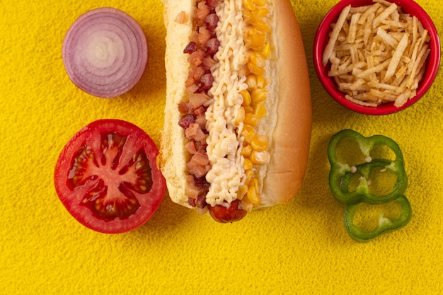 Delizioso hot dog con ingredienti e su sfondo colorato o in legno