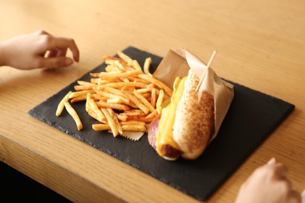 Delizioso hotdog fatto in casa sul tavolo con patatine fritte