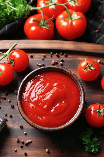 Delizioso ketchup in una ciotola con ingredienti sulla vista dall'alto del vassoio